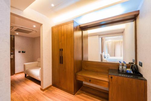 a room with a wooden cabinet and a mirror at Royal Ritis in Shimoga