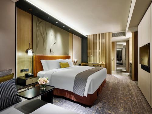 a hotel room with a large bed and a desk at InterContinental Zhuhai by IHG in Zhuhai