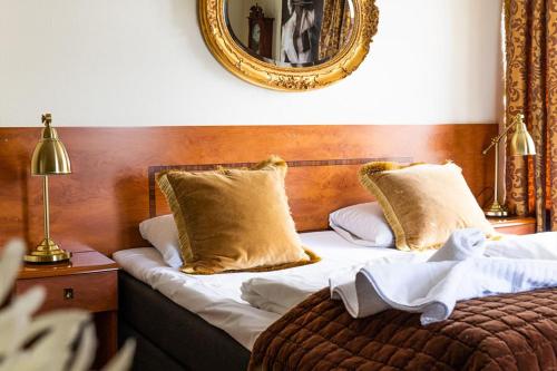 a bedroom with a bed with a mirror on the wall at Reenskaug Hotel in Drøbak