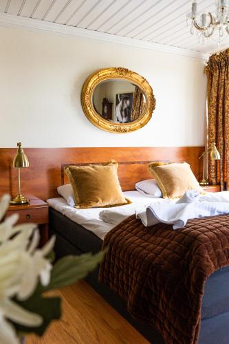 a hotel room with two beds and a mirror at Reenskaug Hotel in Drøbak