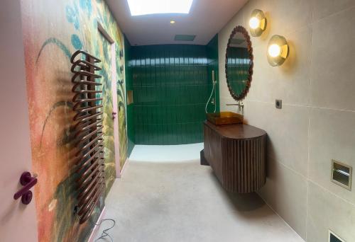a bathroom with a green wall and a mirror at Alpa Nera in Galeria