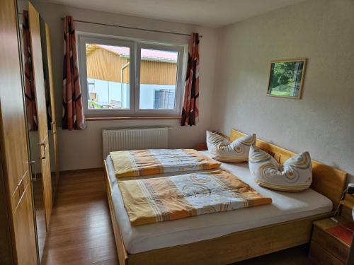 a bedroom with two beds and a window at Ferienwohnungen Simon - Hauserhof in Oberperfuss
