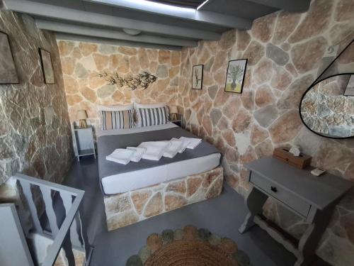a bedroom with a bed in a stone wall at Traditional house in the heart of Naxos in Dhamariónas