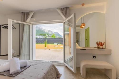 a bedroom with a bed and a large glass window at Apartments Dare & Piccolo in Kaštela