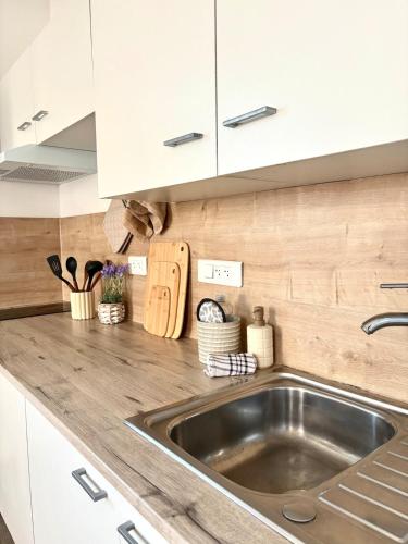 a kitchen with a sink and white cabinets at appartement mauléon in Mauléon