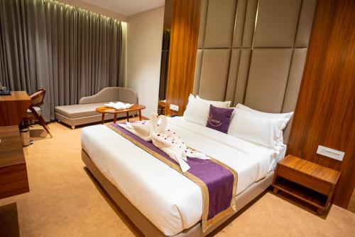 a hotel room with a large bed with shoes on it at Ramnaa Hotel in Jāmb