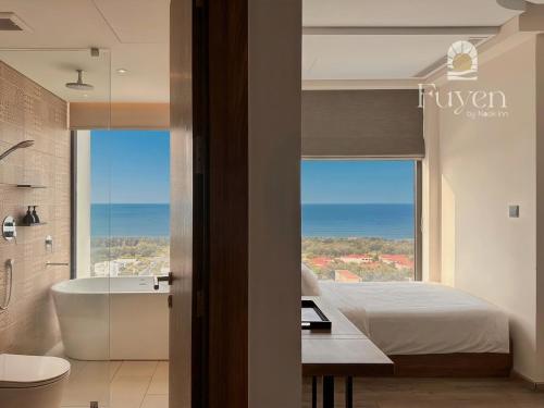 a bedroom with a tub and a bed and a view at Nook Inn - Apec Phu Yen in Tuy Hoa
