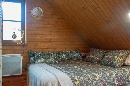 ein Bett in einem Zimmer mit einer Holzwand in der Unterkunft Zemene in Bauska
