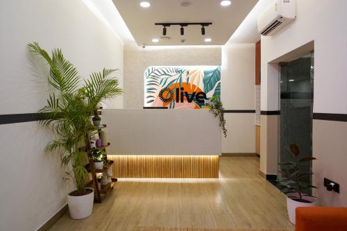 a hallway with plants and a painting on the wall at Olive Hotel JP Nagar Metro by Embassy Group in Bangalore