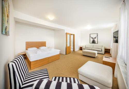 ein Hotelzimmer mit einem Bett und einer Couch in der Unterkunft Element Residence in Lipno nad Vltavou