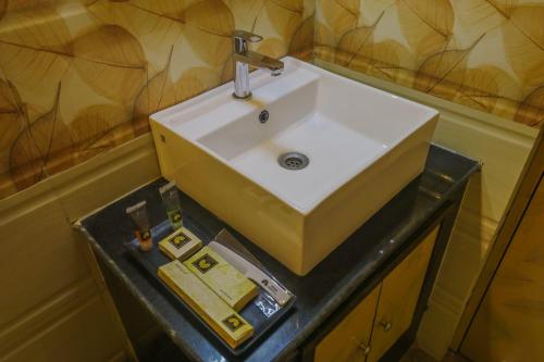 a white sink on a black counter in a bathroom at Mohar Residency - VIP Road in kolkata