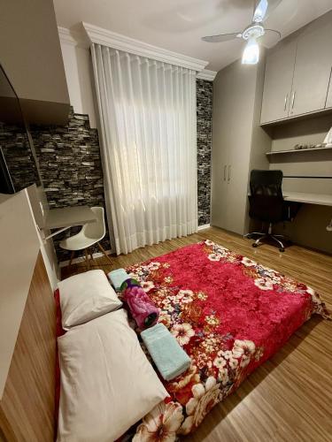 a bedroom with a bed with a red rug on the floor at Apartamento Praia da Costa in Vila Velha