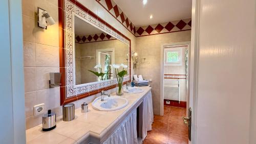 a bathroom with two sinks and a large mirror at Villa in Nature with Yoga Room, Peace and Tranquility in Puigpunyent