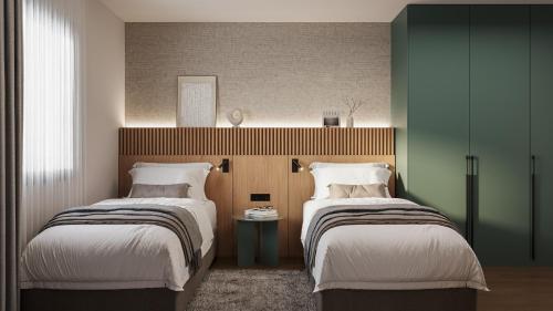 two beds in a room with green walls at Tailormade Hotel Median Niš in Niš