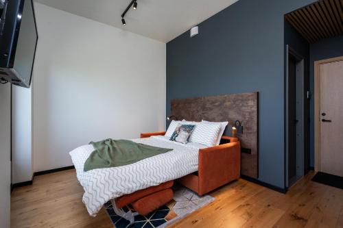 a bedroom with a bed with an orange chair at New apartment in Karlova in Tartu
