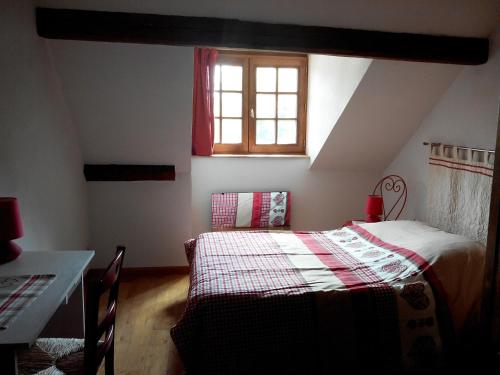 Schlafzimmer mit einem Bett, einem Tisch und einem Fenster in der Unterkunft Gite duplex du vignoble Alsace in Rouffach