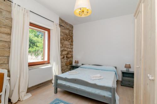 a bedroom with a bed and a window at De Addis Guest House in Aggius