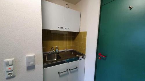 a small kitchen with a sink and a blue door at Alex in Balderschwang