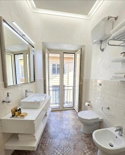 a white bathroom with two sinks and a toilet at ALBATROS Suites&Rooms in Naples