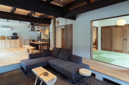 a living room with a blue couch and a kitchen at ひのまきbase-暖- in Uda