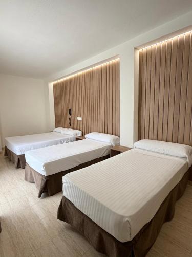 a hotel room with three beds in a room at Hotel Victoria Centro in Almuñécar