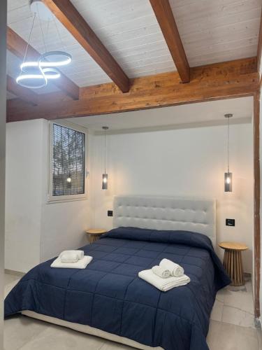 a bedroom with a blue bed with two towels on it at A casa di Raf in Torre Lapillo