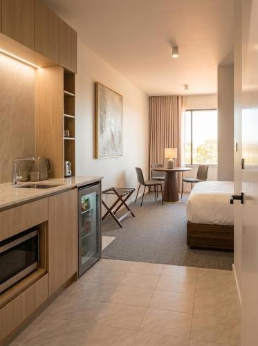 a hotel room with a bed and a kitchen at ROMSEN Nambucca Valley in Macksville