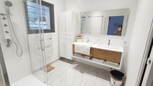 a white bathroom with a sink and a shower at LA MAISON DE MARIE A 8 mn des plages in Perpignan