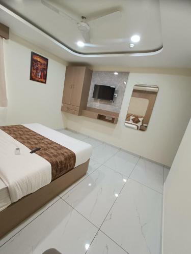 a bedroom with a bed and a tv in it at Hotel Radhe Raas in Vāsad