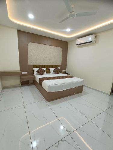 a bedroom with a bed and a white tiled floor at Hotel Radhe Raas in Vāsad