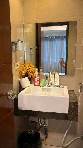 a bathroom with a white sink and a mirror at The Mactan Newtown in Punta Engaño
