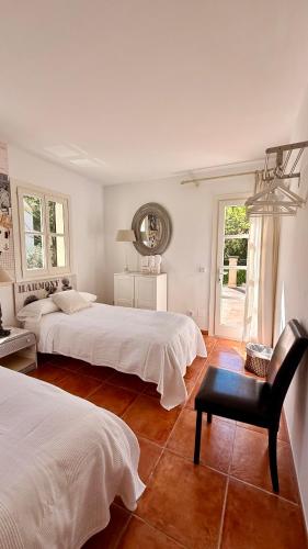 a bedroom with two beds and a chair and a window at Villa in Nature with Yoga Room, Peace and Tranquility in Puigpunyent