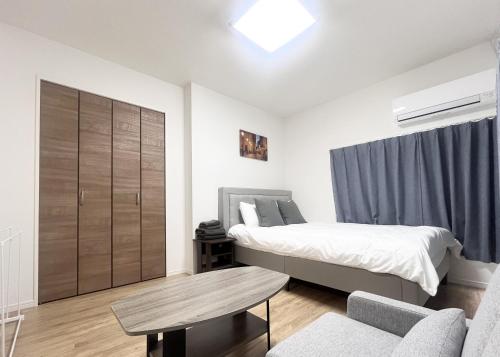 a bedroom with a bed and a table at Hotel Suite 24 in Warabi