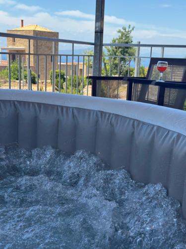 a water fountain with a glass of wine on a balcony at La Pietra Maisonettes in Neokhórion
