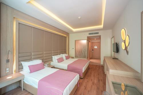 a hotel room with two beds and a television at Orka Lotus Beach in Marmaris