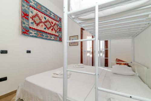 a white bedroom with a bunk bed and a mirror at Villa Oleandro - 2349447 in San Teodoro
