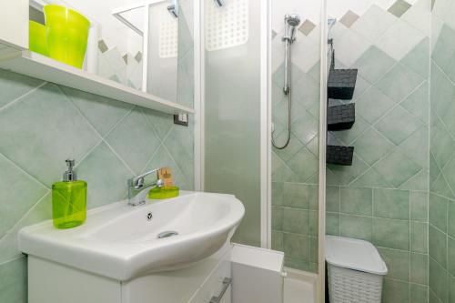 a white bathroom with a sink and a shower at San Teodoro Monti22 vicino spiaggia in San Teodoro