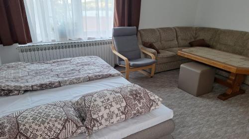 a room with two beds and a chair and a couch at Lake Crown in Ogulin