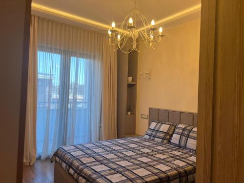 a bedroom with a bed and a chandelier at Cozy corner Komitas in Yerevan