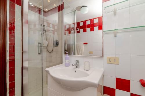 a white bathroom with a sink and a shower at Trilocale Taverna 80 mt spiaggia in Porto Taverna