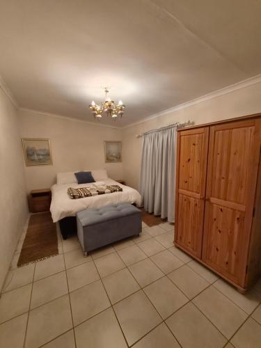 a bedroom with a bed and a chandelier at Karoo-rus in Montagu