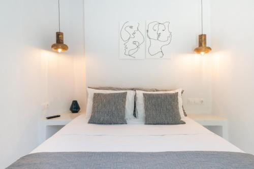 a bedroom with a white bed with three pillows at Edem Garden Suite in Andros