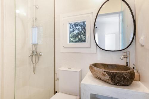 a bathroom with a wooden sink and a mirror at Edem Garden Suite in Andros
