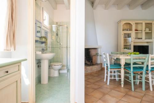 a kitchen and a dining room with a table and chairs at Alloggio Poseidone in Villasimius