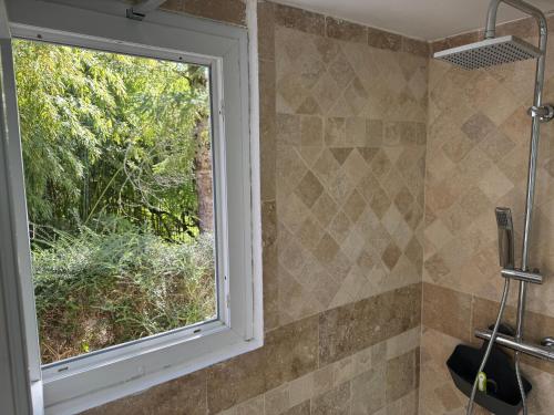 a window in a bathroom with a shower at Gîte Le Bellevue avec piscine privative - climatisation in Dolmayrac
