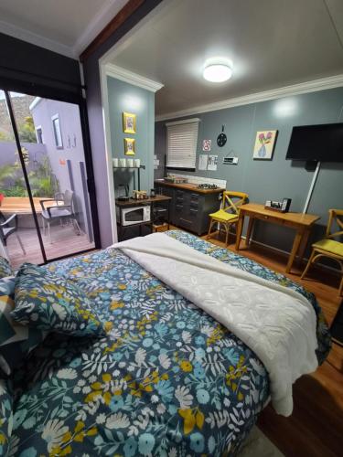 a bedroom with a bed and a kitchen with a table at Stil Karoo in Montagu