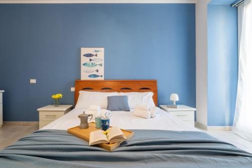 a blue bedroom with a bed with a tray with books at Alloggio Nettuno in Villasimius