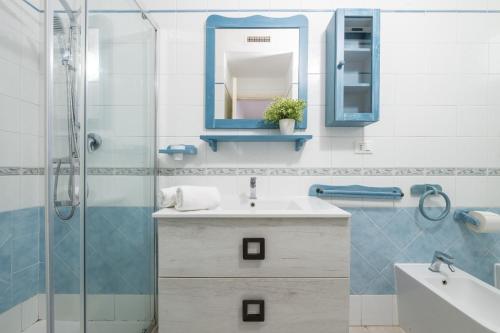 a bathroom with a sink and a mirror and a shower at Alloggio Nettuno in Villasimius