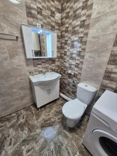 a bathroom with a toilet and a sink and a mirror at Къща за гости Бавария in Ravda