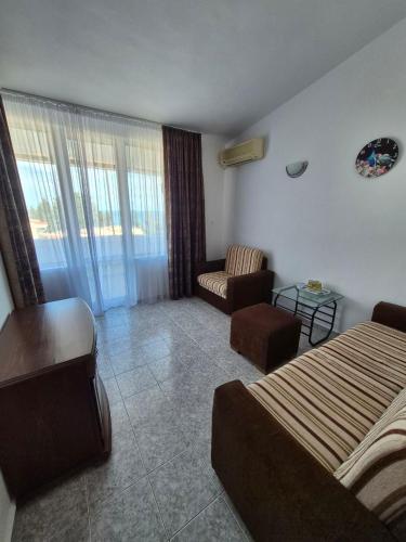 a hotel room with a bed and a couch at Къща за гости Бавария in Ravda